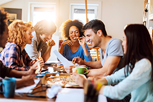 People sitting around table eating pizza.